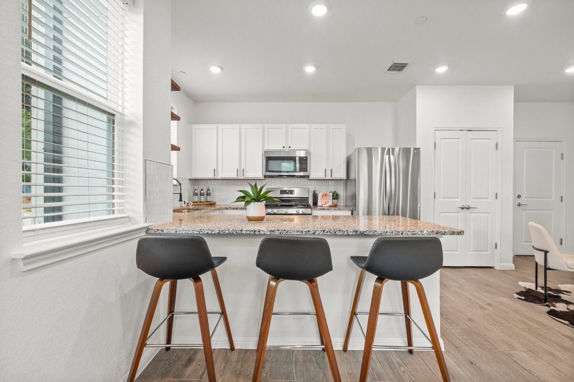 9015 Cattle Baron Path, Unit 2005 Austin, TX 78747 - Photo 8 of 37 a kitchen with stainless steel appliances granite countertop a stove a sink a microwave a refrigerator and cabinets