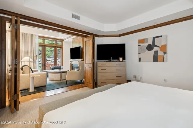 a bedroom with a bed and a flat screen tv