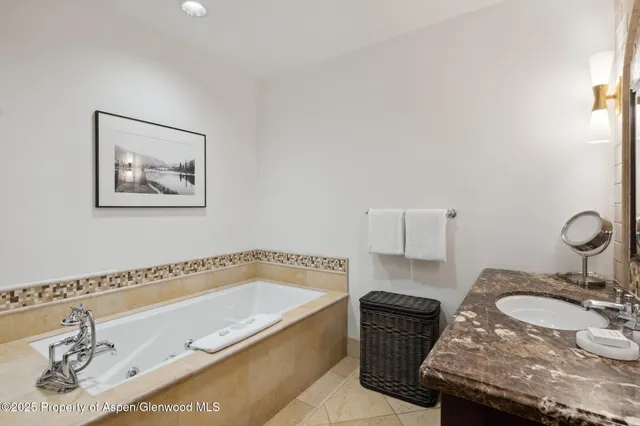 a bathroom with a granite countertop bathtub and a sink