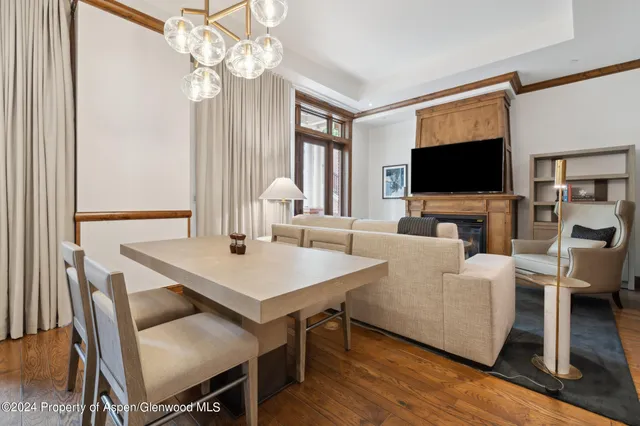 a living room with furniture a flat screen tv and a chandelier