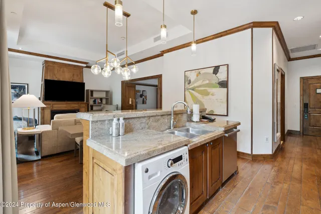 a view of a kitchen counter space wooden floor and a chandelier