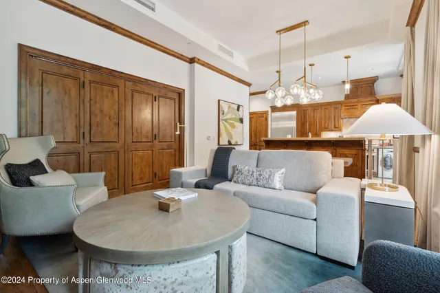 a living room with furniture and a chandelier