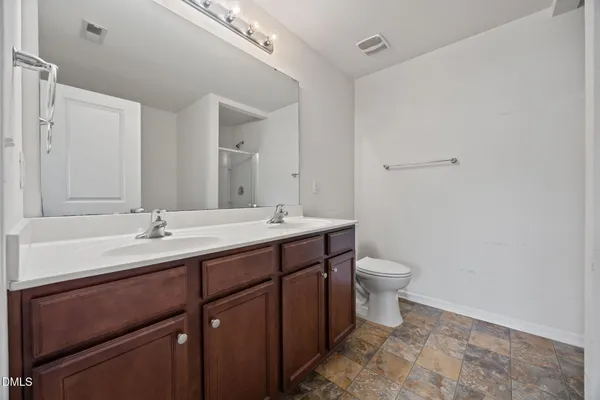a bathroom with a double vanity sink and a toilet