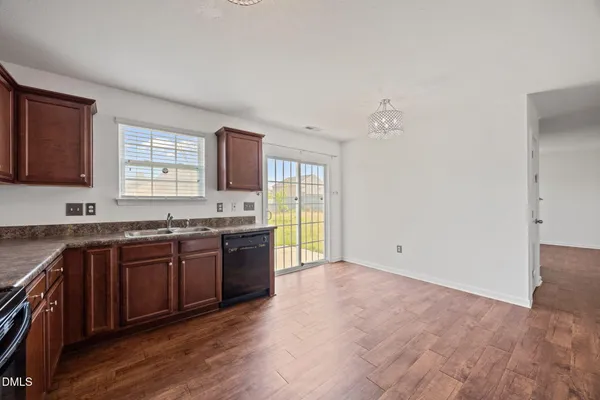a large kitchen with granite countertop a stove a sink and a granite counter top