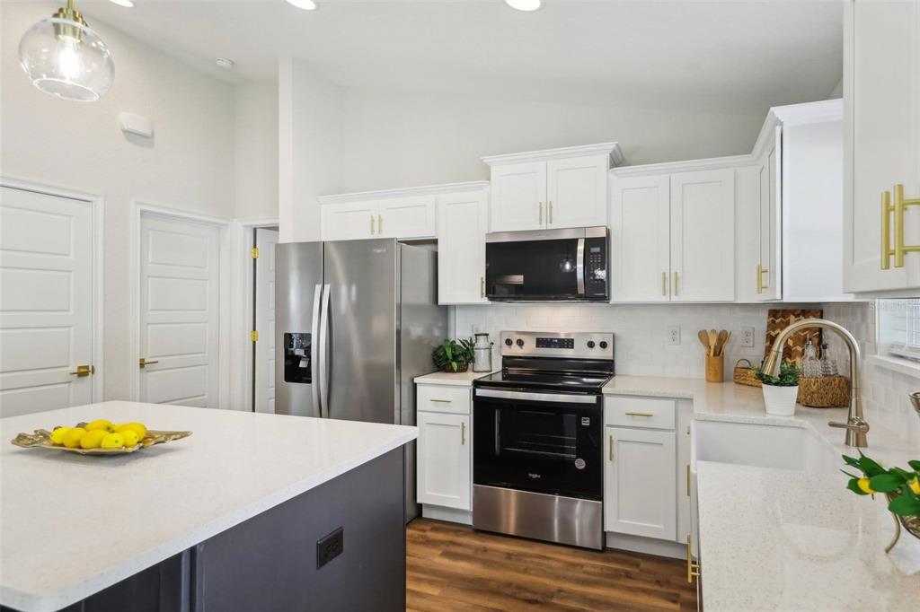 7217 Hemlock Loop Ocala, FL 34472 - Photo 18 of 36 a kitchen with stainless steel appliances a stove a sink and a refrigerator