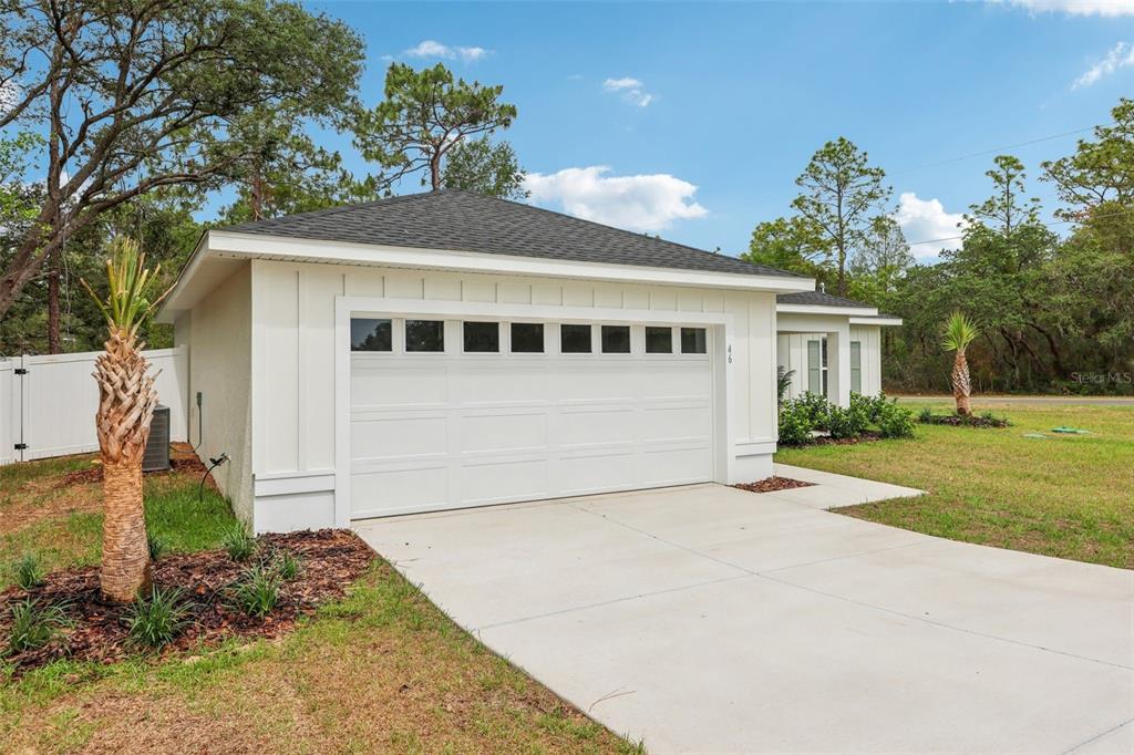 7217 Hemlock Loop Ocala, FL 34472 - Photo 2 of 27 a front view of a house with a yard and garage