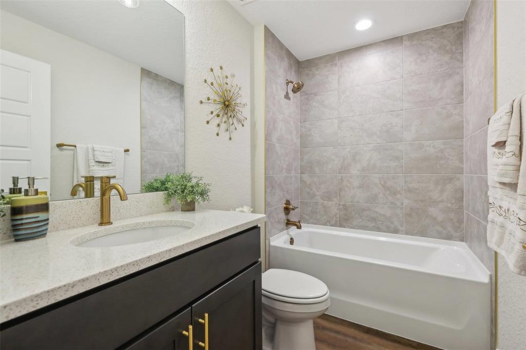 7217 Hemlock Loop Ocala, FL 34472 - Photo 28 of 36 a bathroom with a sink a toilet a mirror a bathtub and shower