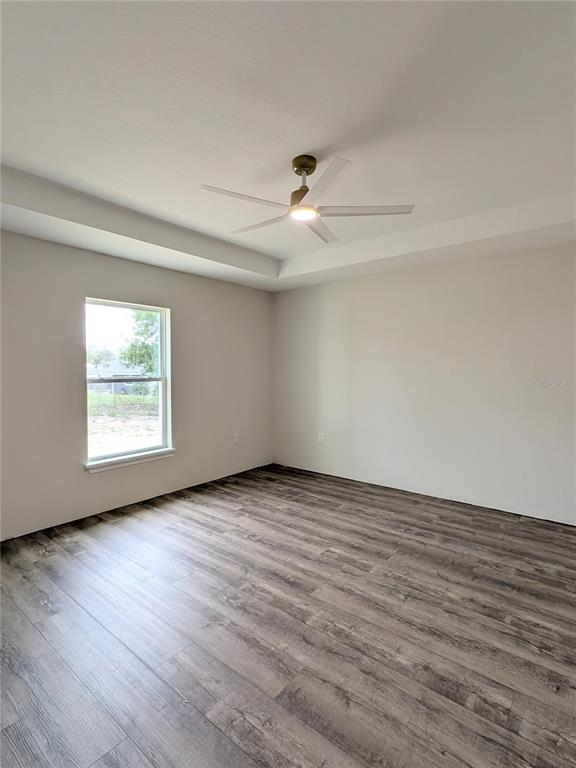 7217 Hemlock Loop Ocala, FL 34472 - Photo 6 of 36 wooden floor in an empty room with a window