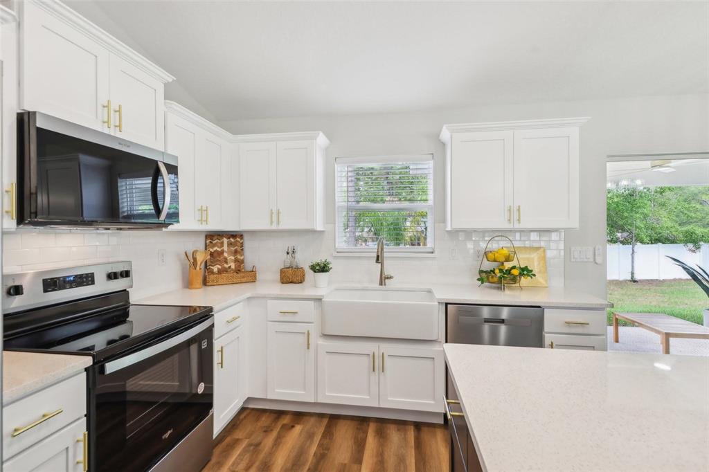 7217 Hemlock Loop Ocala, FL 34472 - Photo 7 of 27 a kitchen with stainless steel appliances a stove a sink cabinets and a window