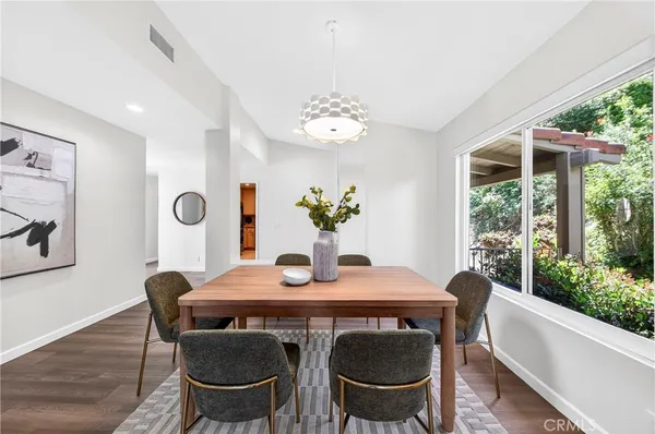 a dining room with furniture a large window and wooden floor