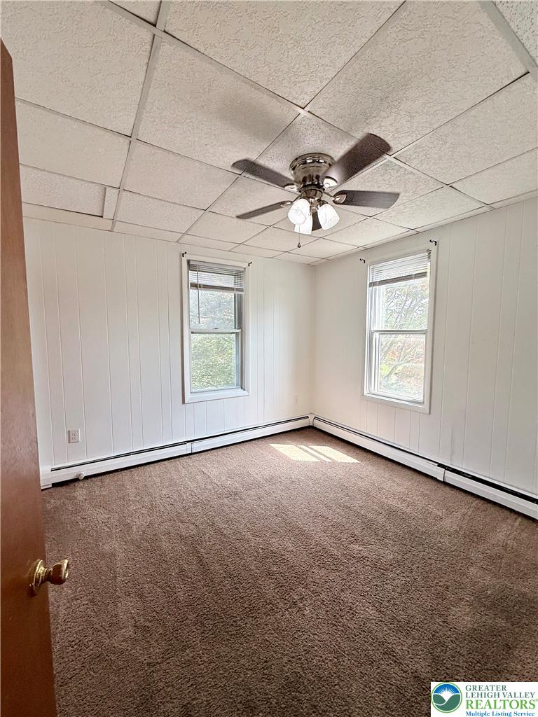 5540 Main Street Whitehall, PA 18052 - Photo 38 of 53 A well-lit bedroom features plush carpeting and efficient baseboard heating for comfortable living.