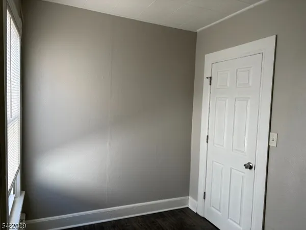 an empty room with wooden floor and closet