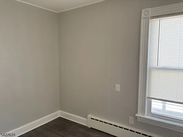 a view of a small space with wooden floor and a window