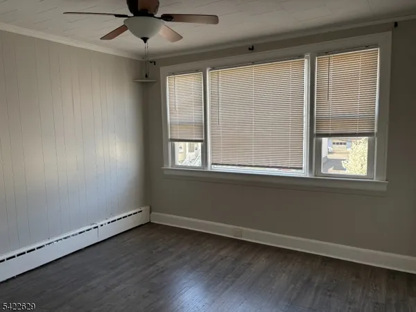 an empty room with a window and ceiling fan
