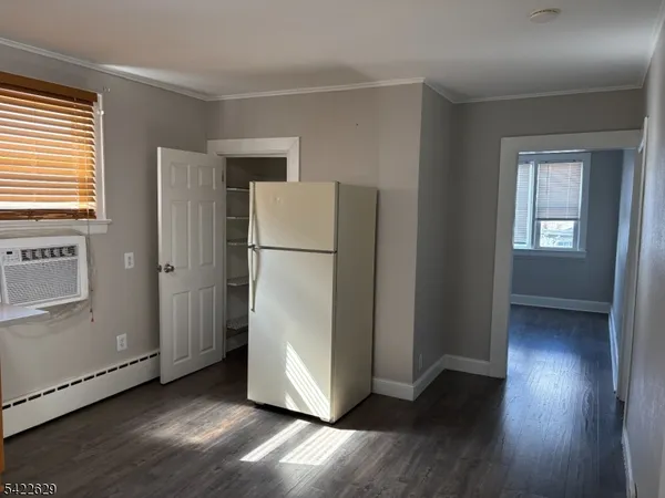 a view of a kitchen with wooden floor and a refrigerator