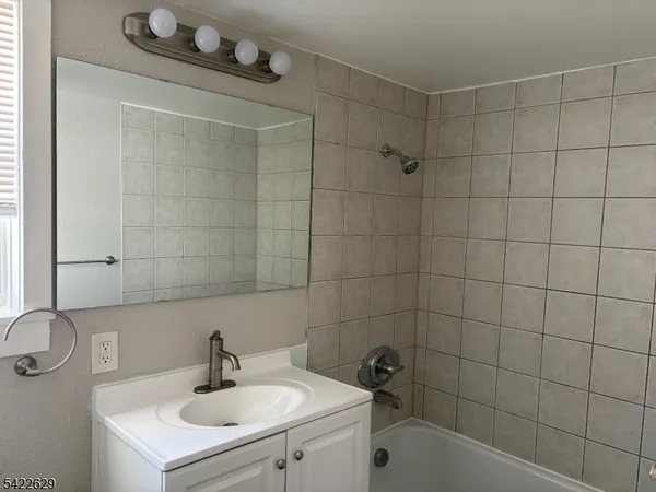 a bathroom with a sink shower and a mirror