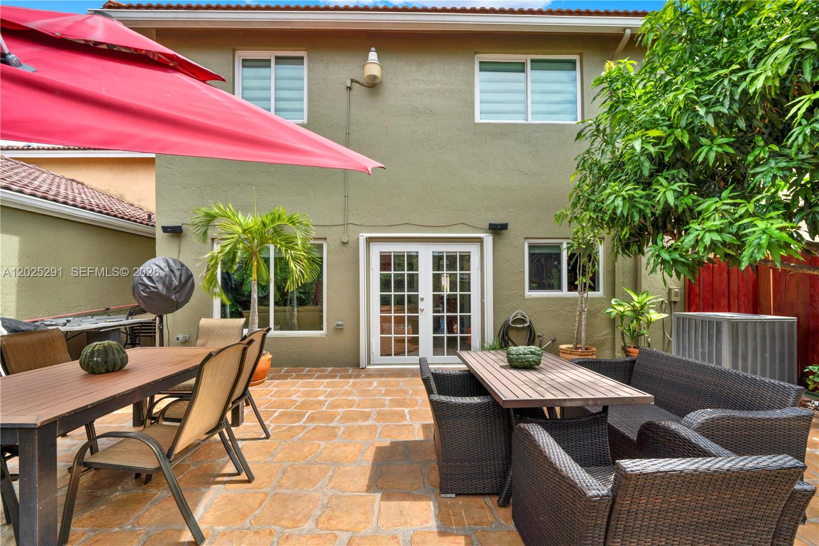 10006 Southwest 162nd Path Miami, FL 33196 - Photo 34 of 40 a patio with a table and chairs under an umbrella