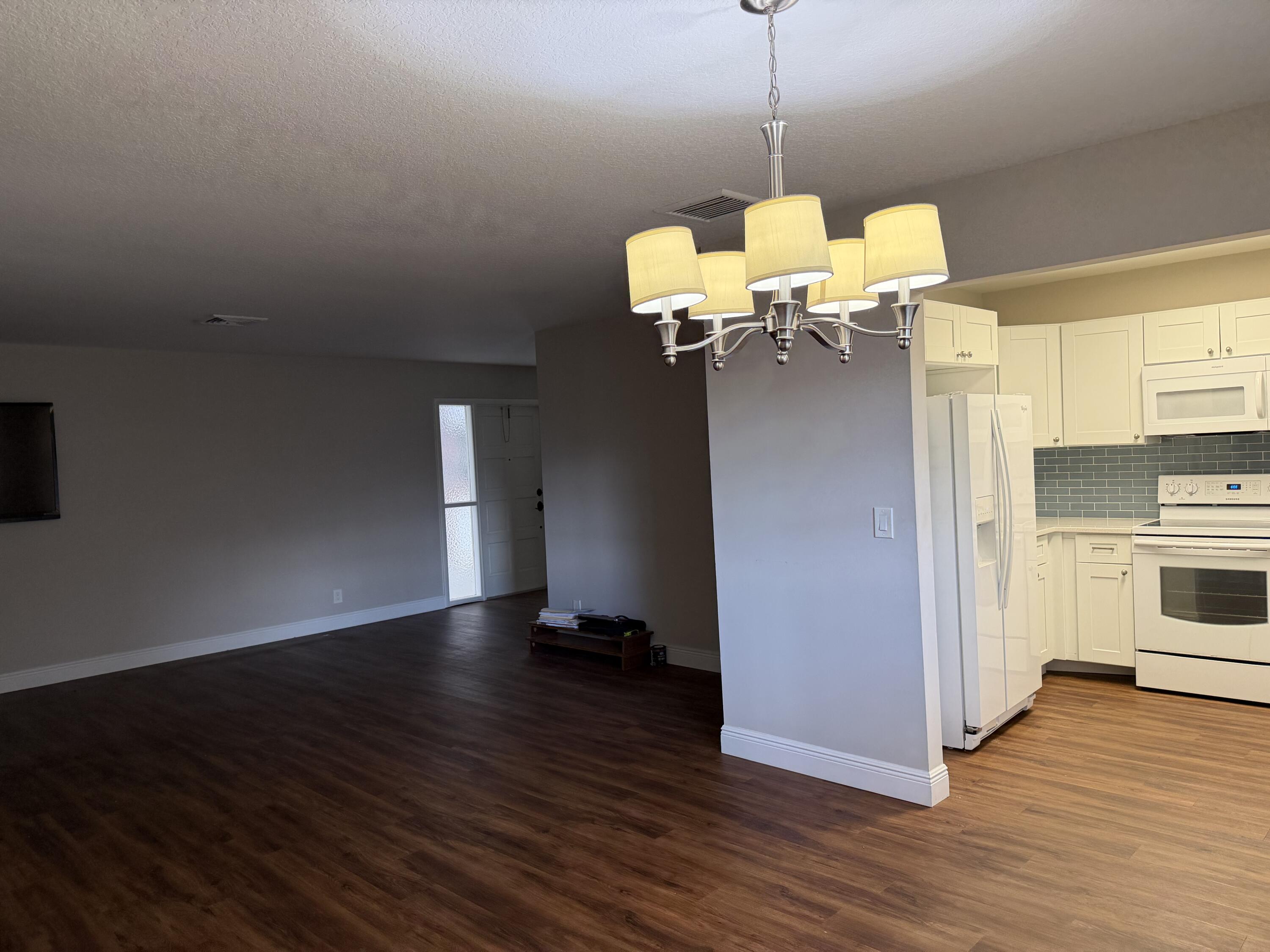 340 Orange Tree Drive, Unit 1 Atlantis, FL 33462 - Photo 13 of 23 a view of a kitchen with wooden floor and a ceiling fan