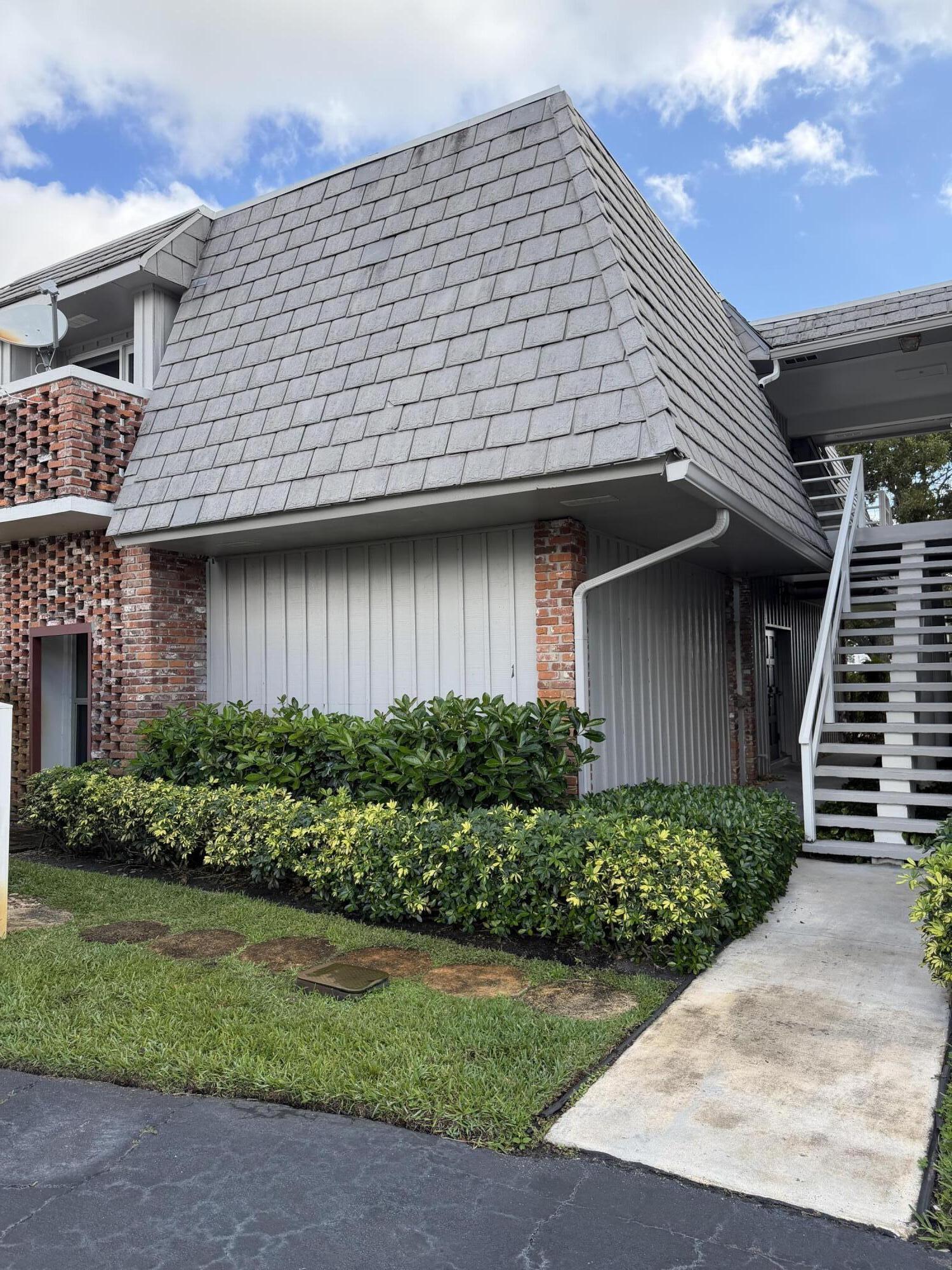 340 Orange Tree Drive, Unit 1 Atlantis, FL 33462 - Photo 2 of 23 a front view of a house with garden