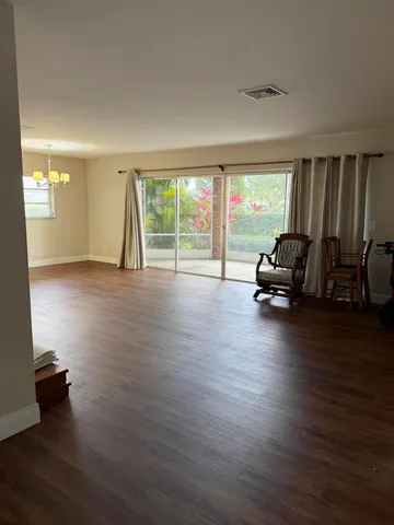 an empty room with wooden floor and a window