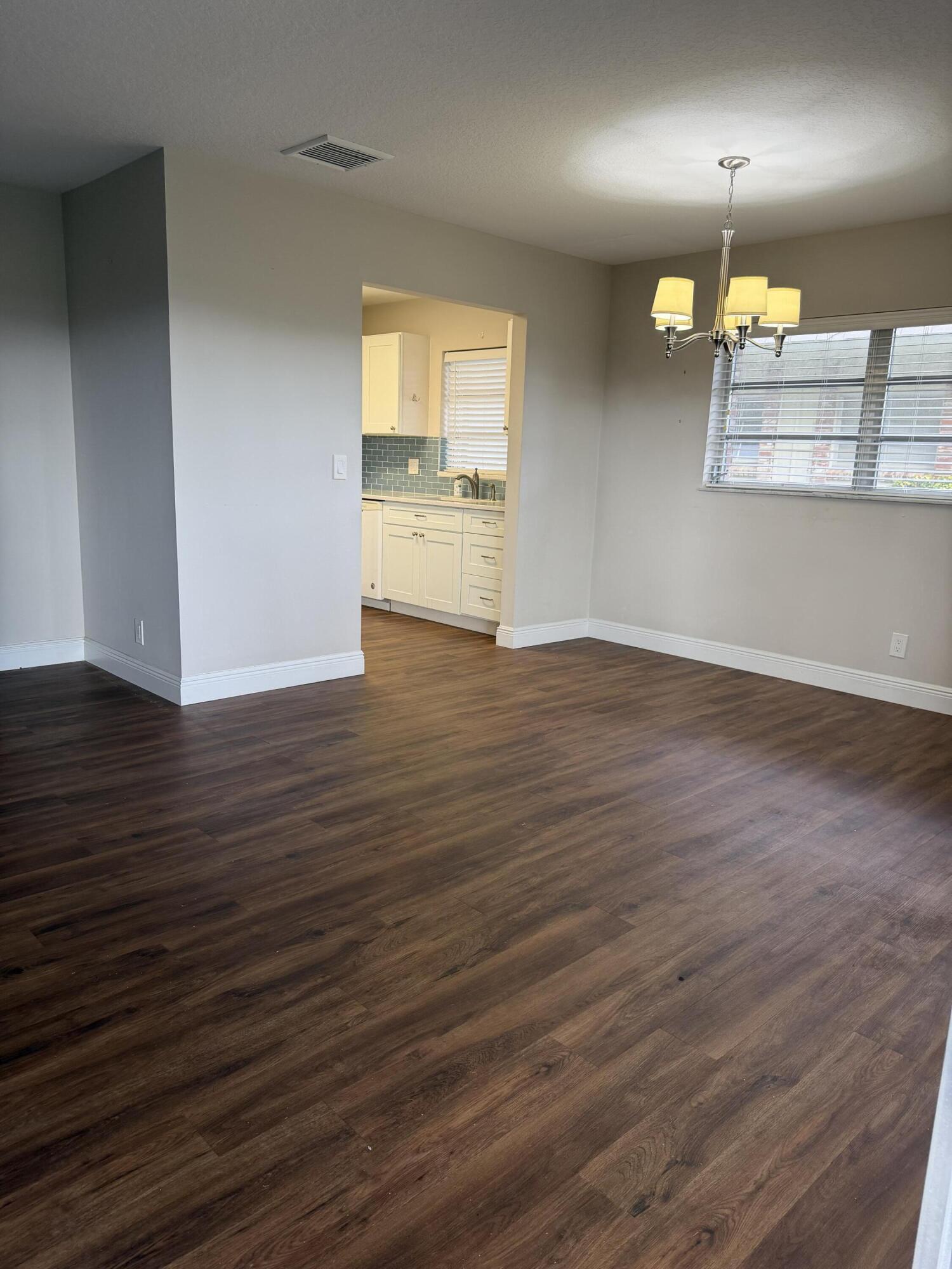 340 Orange Tree Drive, Unit 1 Atlantis, FL 33462 - Photo 9 of 23 an empty room with wooden floor and a window