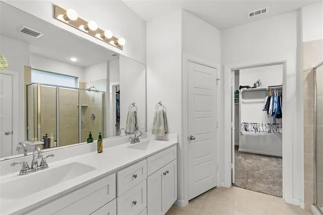 a bathroom with a double vanity sink a mirror and a shower