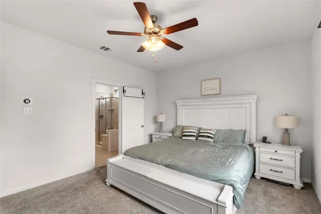 a bedroom with a large bed and ceiling fan