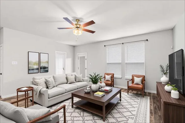 a living room with furniture a flat screen tv and a window