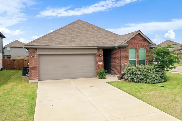 a front view of a house with a garden and plants