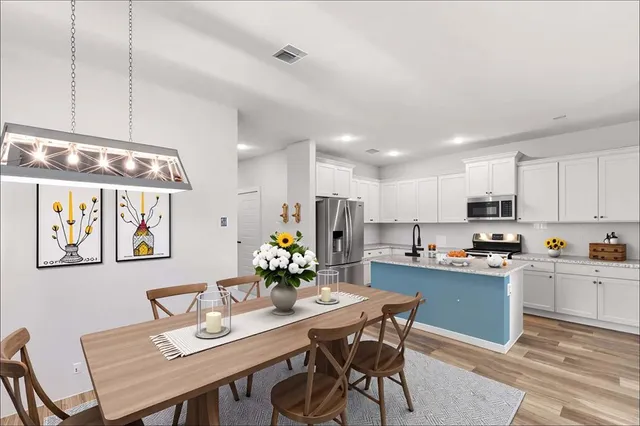 a kitchen with a dining table cabinets and stainless steel appliances