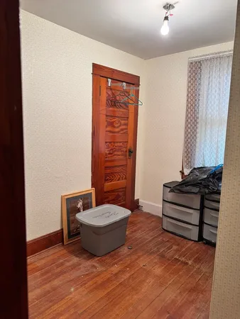 a view of a room with a bench and a wooden floor
