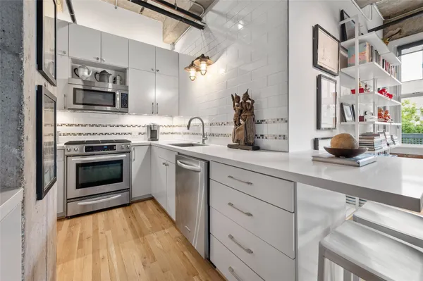 a kitchen with stainless steel appliances a stove a sink and a microwave