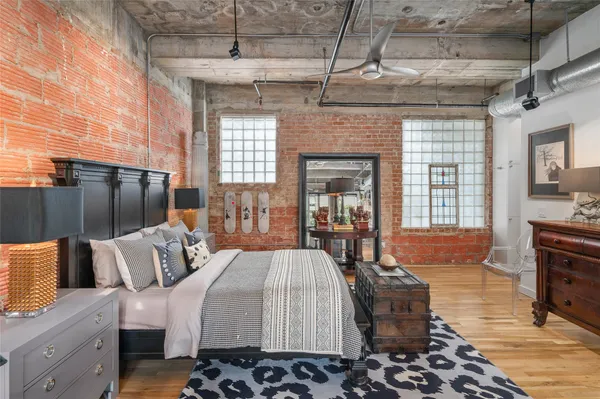 a large bedroom with a bed and wooden floor