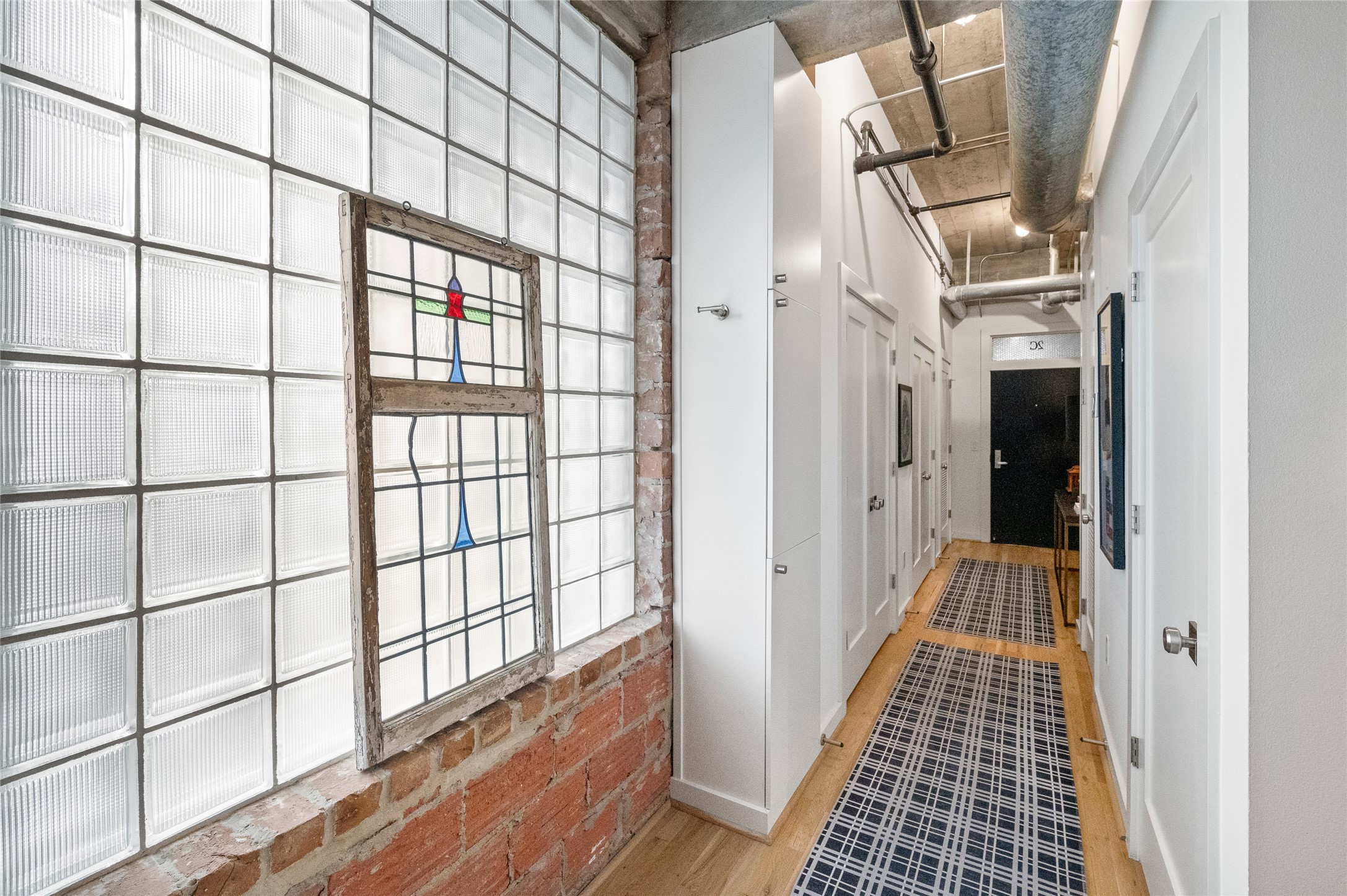 204 Travis Street, Unit 2C Houston, TX 77002 - Photo 6 of 28 a view of a hallway with wooden floor and door