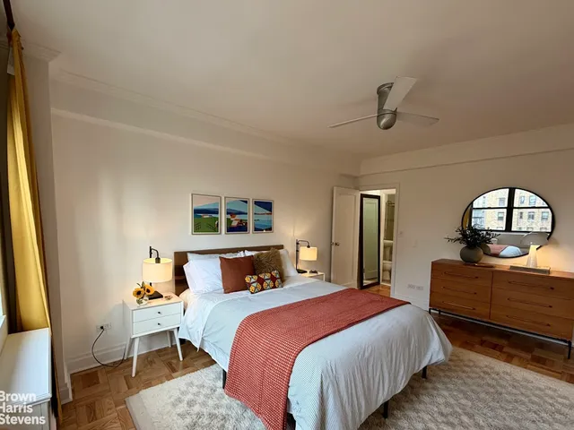 a bedroom with a bed and a dresser with mirror