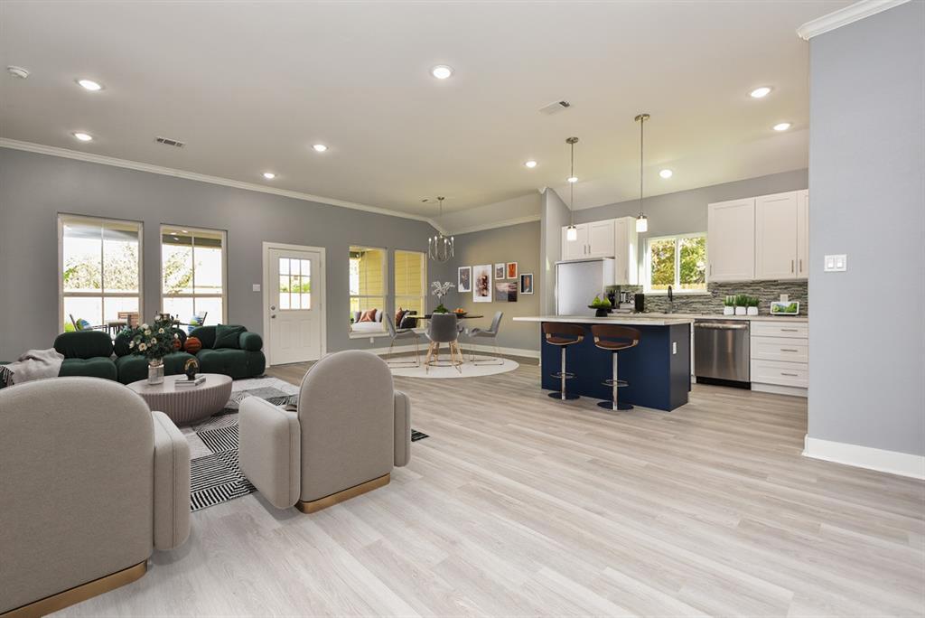a large room with kitchen island a counter top space a sink stainless steel appliances and cabinets