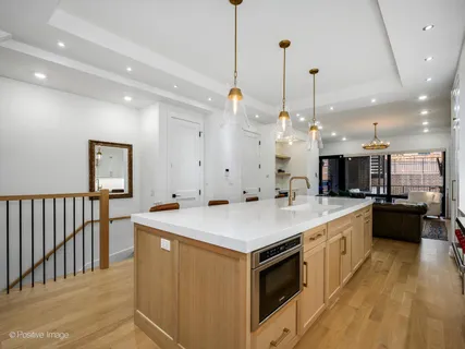 a large kitchen with kitchen island a sink a counter space and stainless steel appliances
