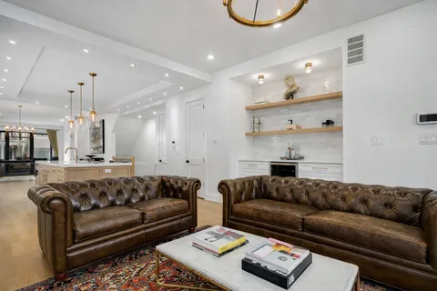 a living room with furniture and a chandelier