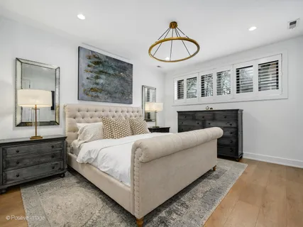 a bedroom with a large bed and a chandelier