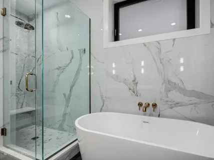 a white bath tub sitting next to a shower