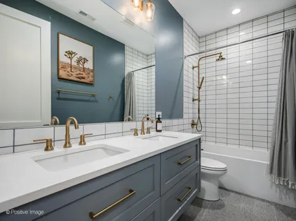 a bathroom with a double vanity sink toilet and shower