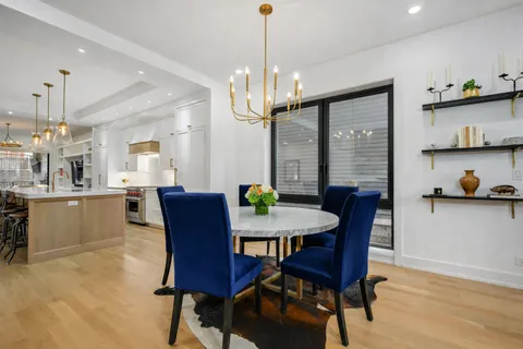 a view of a dining room with furniture a chandelier and wooden floor