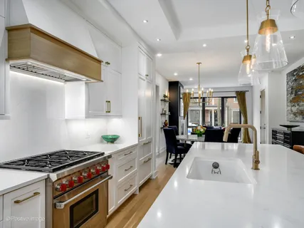 a kitchen that has a lot of cabinets in it and wooden floors