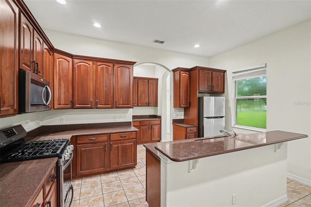4819 Indian Deer Road Windermere, FL 34786 - Photo 10 of 30 a kitchen with stainless steel appliances granite countertop a stove a sink and a microwave