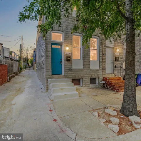 a view of a brick house with large windows and a tree