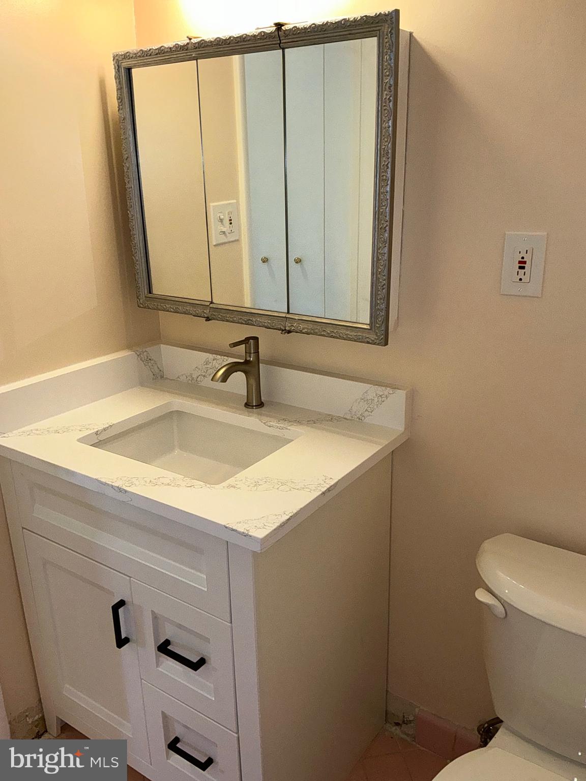303 Charlton Court Silver Spring, MD 20902 - Photo 18 of 45 a bathroom with a sink a toilet and mirror