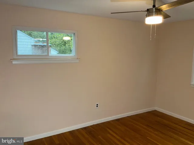 an empty room with a window and wooden floor