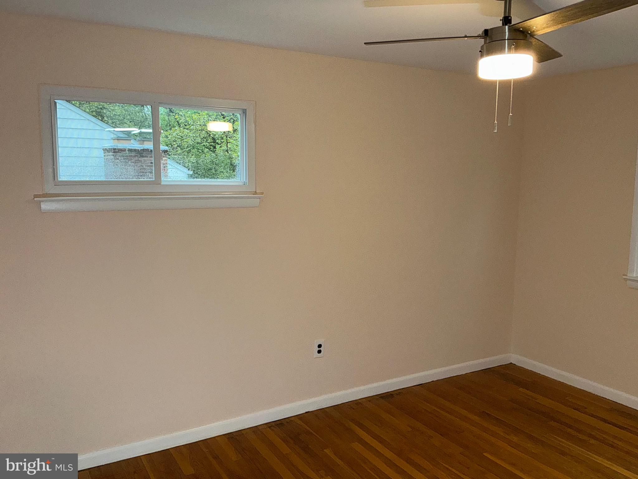 303 Charlton Court Silver Spring, MD 20902 - Photo 19 of 45 an empty room with a window and wooden floor