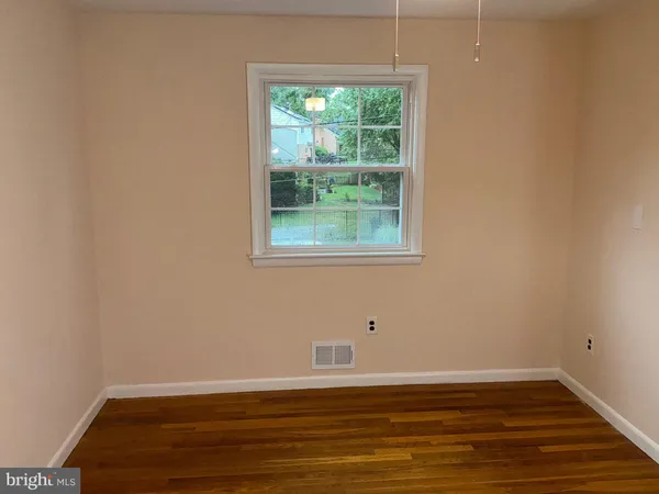 a view of a room with wooden floor and window