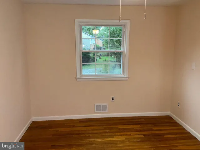 a view of a room with wooden floor and window